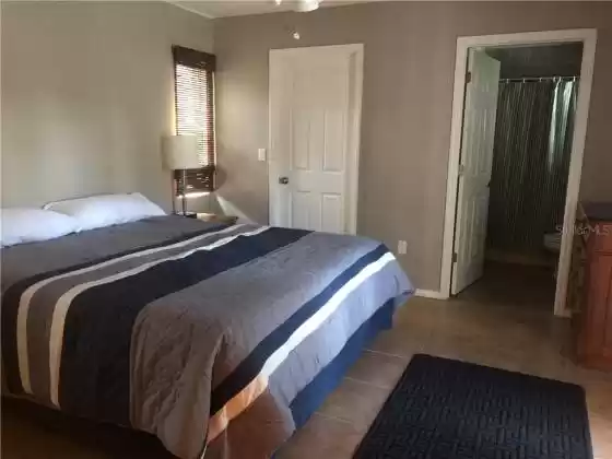Master Bedroom has a king bed, ceiling fan and private bathroom