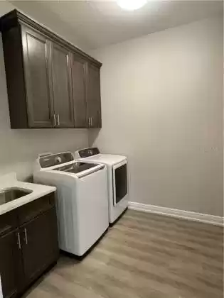 Gigantic Laundry Room with space enough to add a folding area and a whole lot more!  Acorn cabinetry and large laundry sink included for added wash space, mini pet station,  and storage