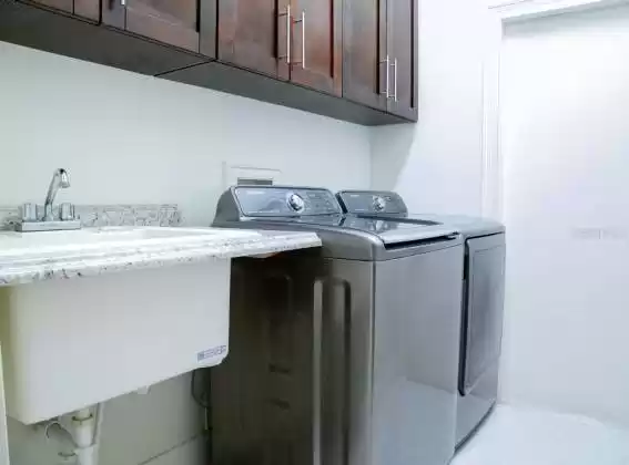 The indoor laundry room is large and has a high-end washer and dryer.