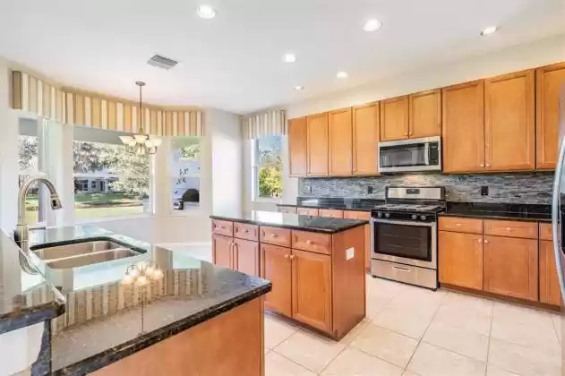 Kitchen has wood cabinetry and granite counter-tops