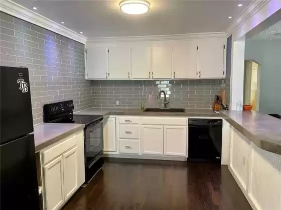 Kitchen with updated subway tile and refinished wood flooring