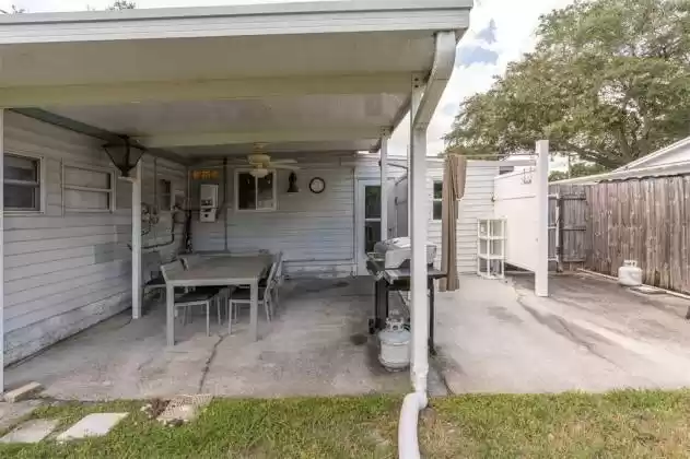The back of the home has a nice large concrete deck - and notice - there is an outdoor shower to the right! Also a good gutter system to keep water away from the porch area
