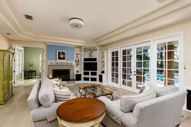 Gas fireplace for cooler evenings- Note the wall of French doors open the family room & pool area on the pool lanai-